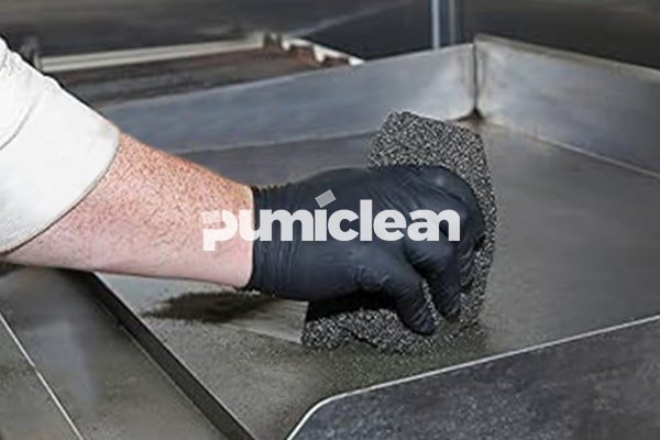 grill cleaning brick in use on commercial griddle