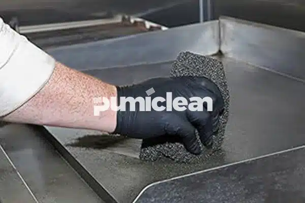 grill cleaning brick in use on commercial griddle